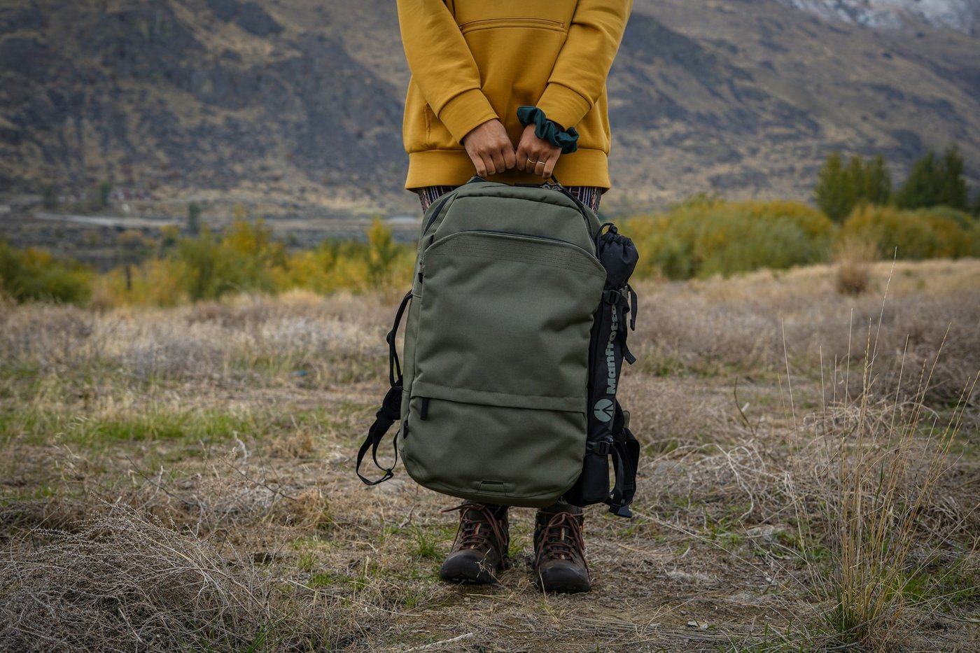Hiker wearing a rugged backpack while walking through a forest trail